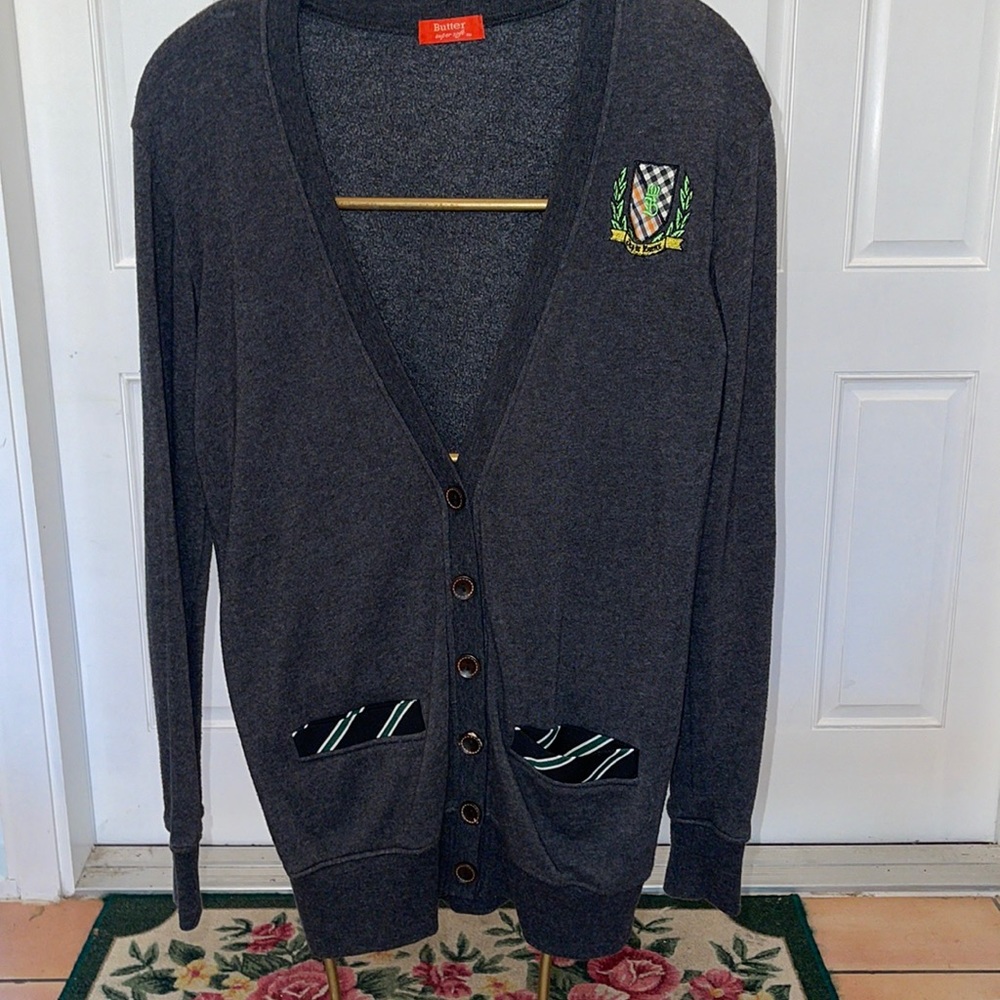 BUTTER grey cardigan with crest and trim.